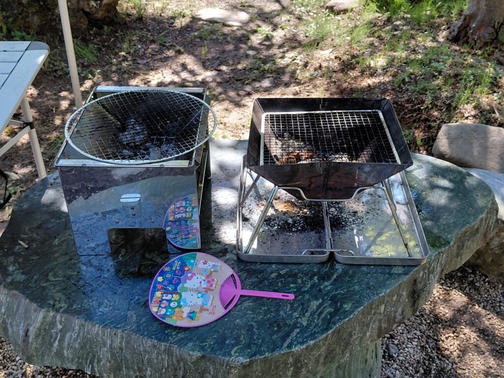 石のテーブルに卓上コンロを2つ置いてある写真。ほかのものを置くスペースがありません。