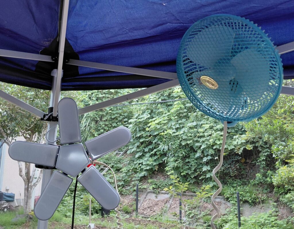 庭のタープテントに取り付けたLEDライトとミニ扇風機の写真