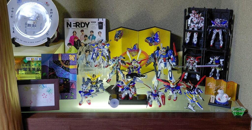 床の間の棚に飾られたガンプラのコレクションと記念品の写真