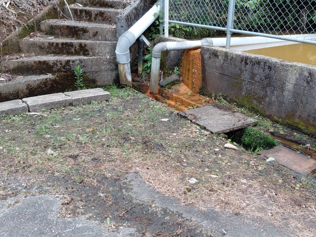 防火水槽前の様子と溢れ出した水路