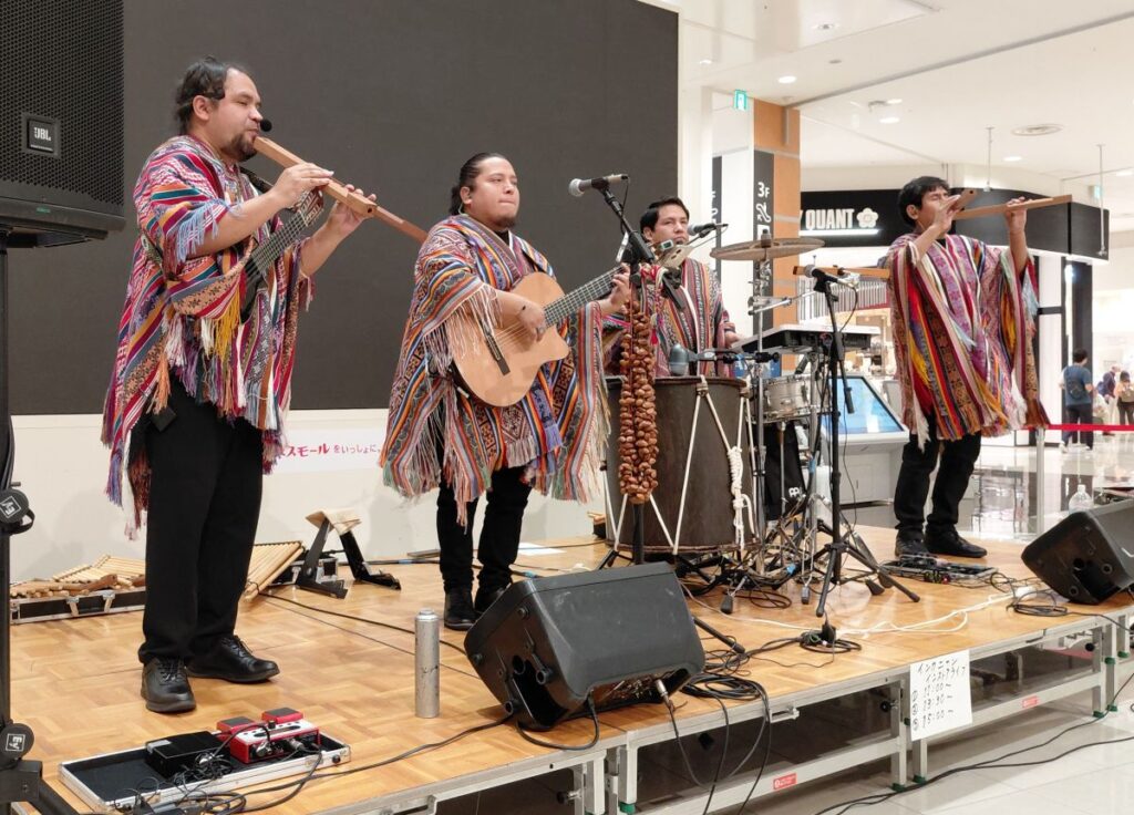 民族衣装の4人組がケーナやギター、パーカッションを演奏しているインカニャンのライブ全景。