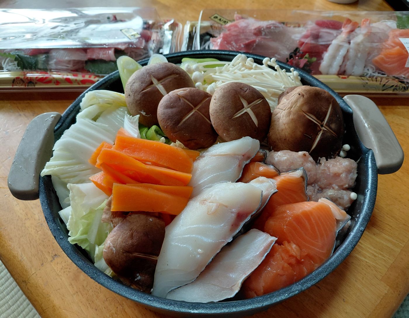 冬の食卓を彩る漁師鍋。鮭や白身魚、つみれ、しいたけ、白菜など彩り豊かな具材をたっぷり盛り付けた鍋の全景。