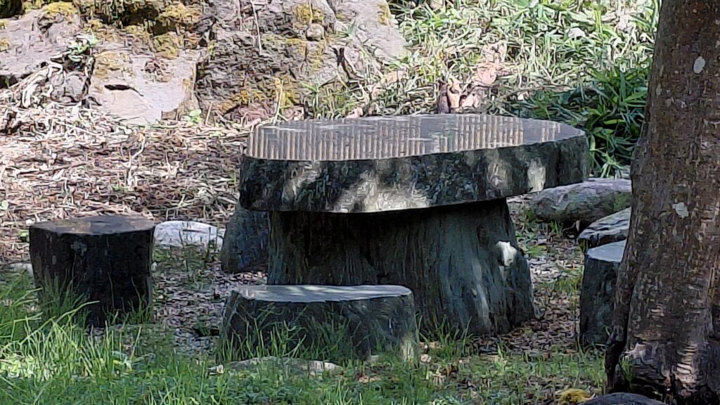 巻の家の庭にある石のテーブルと椅子、自然の中でくつろげる屋外スペース