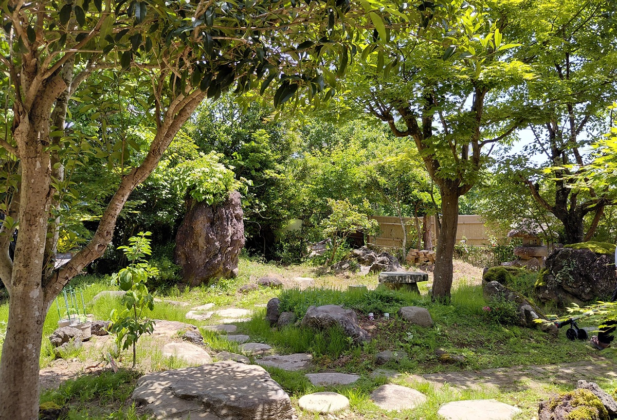 巻の家の庭レンタルで利用できる、木々と庭石に囲まれた里山の庭